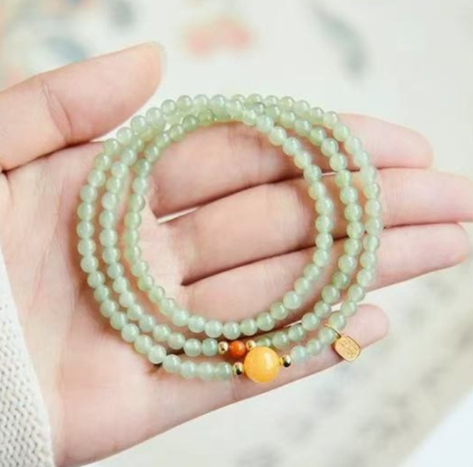 The Hetian jade bracelet features a ethnic style with three layers of natural high-ice green jade and amber in the south red color