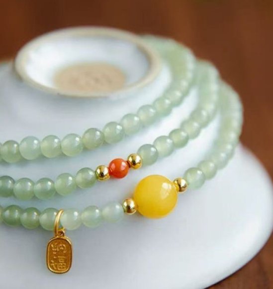The Hetian jade bracelet features a ethnic style with three layers of natural high-ice green jade and amber in the south red color