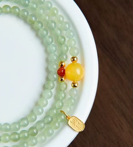 The Hetian jade bracelet features a ethnic style with three layers of natural high-ice green jade and amber in the south red color