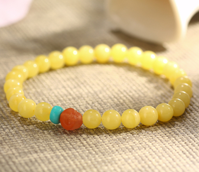 A simple, fashionable and elegant women's amber bracelet with a turquoise red Buddha head is available for one-piece delivery