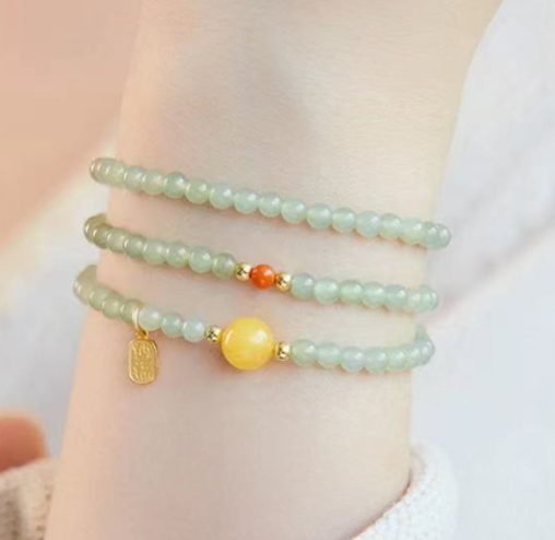 The Hetian jade bracelet features a ethnic style with three layers of natural high-ice green jade and amber in the south red color