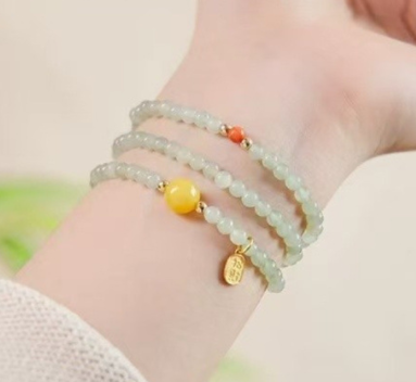 The Hetian jade bracelet features a ethnic style with three layers of natural high-ice green jade and amber in the south red color