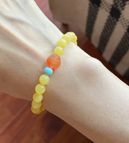 A simple, fashionable and elegant women's amber bracelet with a turquoise red Buddha head is available for one-piece delivery