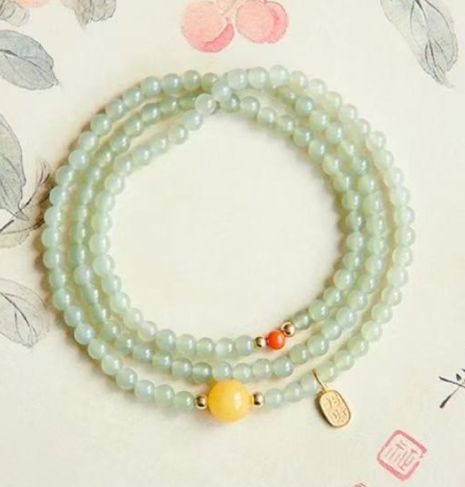 The Hetian jade bracelet features a ethnic style with three layers of natural high-ice green jade and amber in the south red color