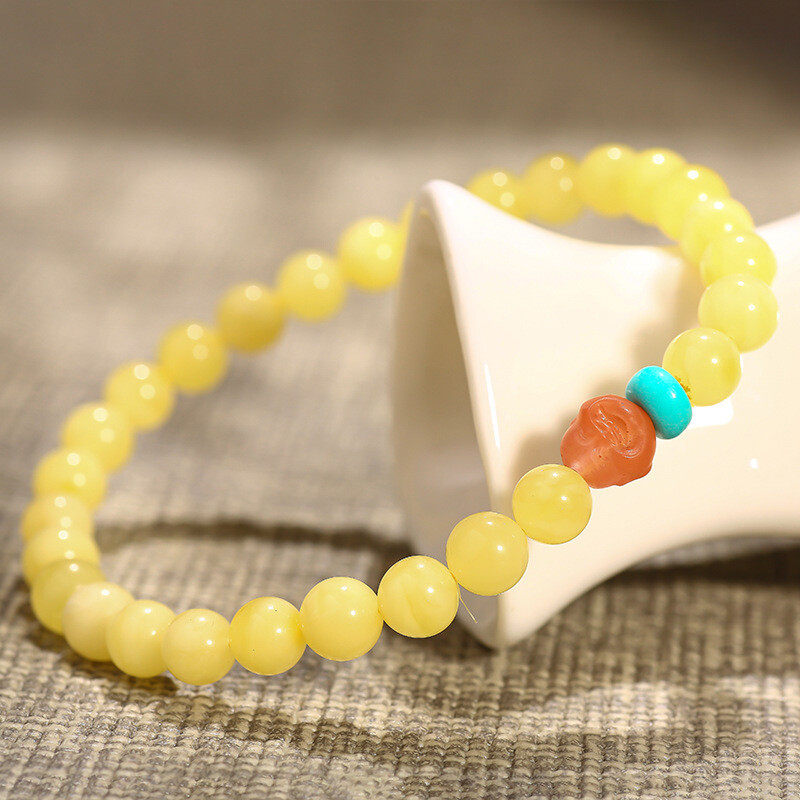 A simple, fashionable and elegant women's amber bracelet with a turquoise red Buddha head is available for one-piece delivery