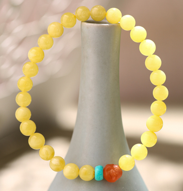 A simple, fashionable and elegant women's amber bracelet with a turquoise red Buddha head is available for one-piece delivery