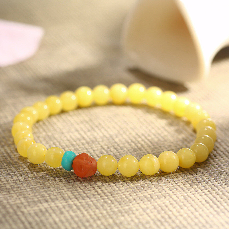 A simple, fashionable and elegant women's amber bracelet with a turquoise red Buddha head is available for one-piece delivery
