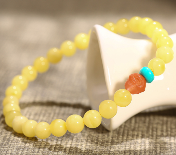 A simple, fashionable and elegant women's amber bracelet with a turquoise red Buddha head is available for one-piece delivery