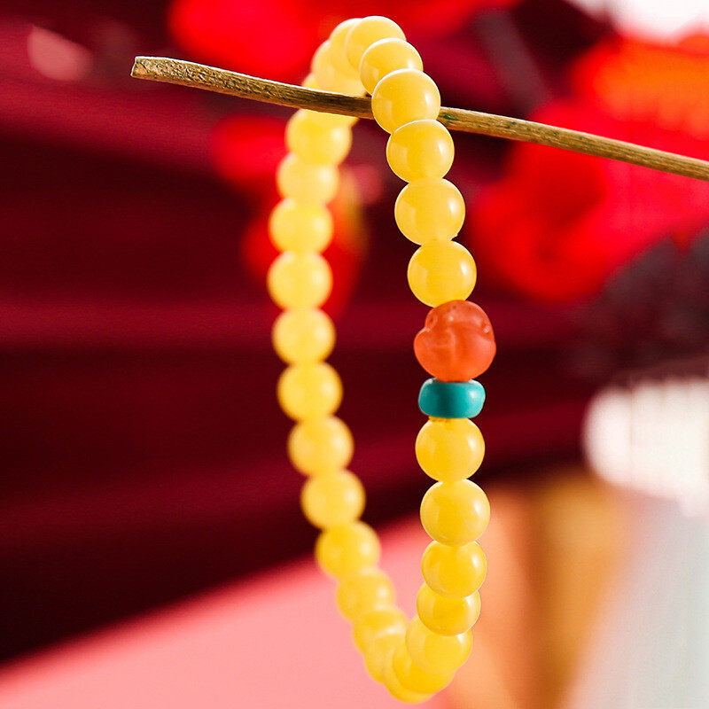 A simple, fashionable and elegant women's amber bracelet with a turquoise red Buddha head is available for one-piece delivery