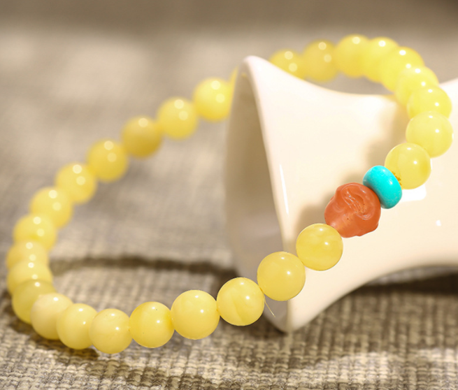 A simple, fashionable and elegant women's amber bracelet with a turquoise red Buddha head is available for one-piece delivery
