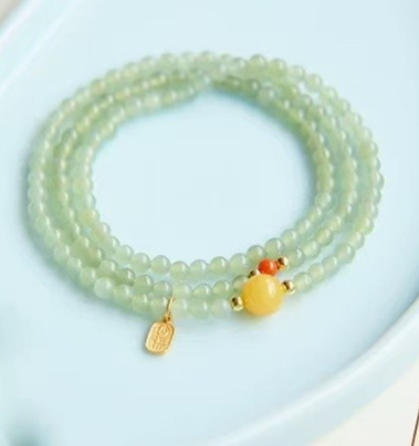 The Hetian jade bracelet features a ethnic style with three layers of natural high-ice green jade and amber in the south red color