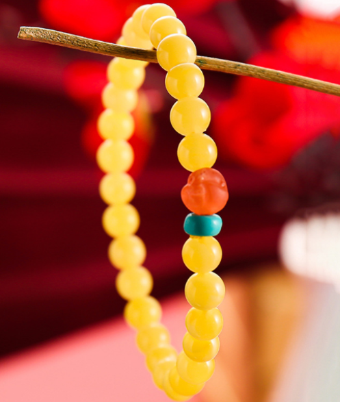 A simple, fashionable and elegant women's amber bracelet with a turquoise red Buddha head is available for one-piece delivery